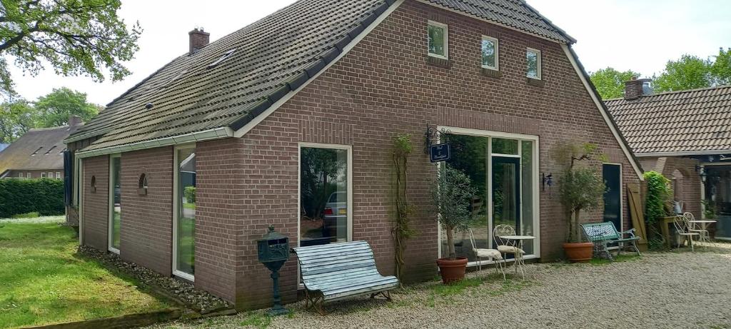 Noord-SleenDe Oude Smederij的砖房,前面有长凳