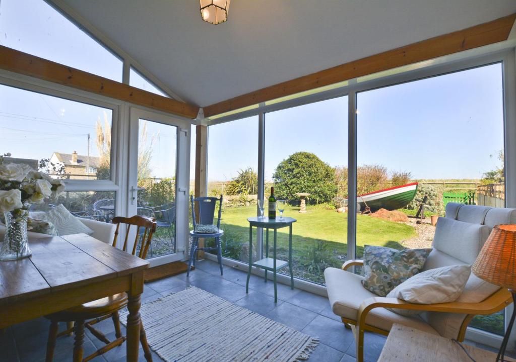 安布尔Beach View Cottage的客厅设有大窗户和桌椅