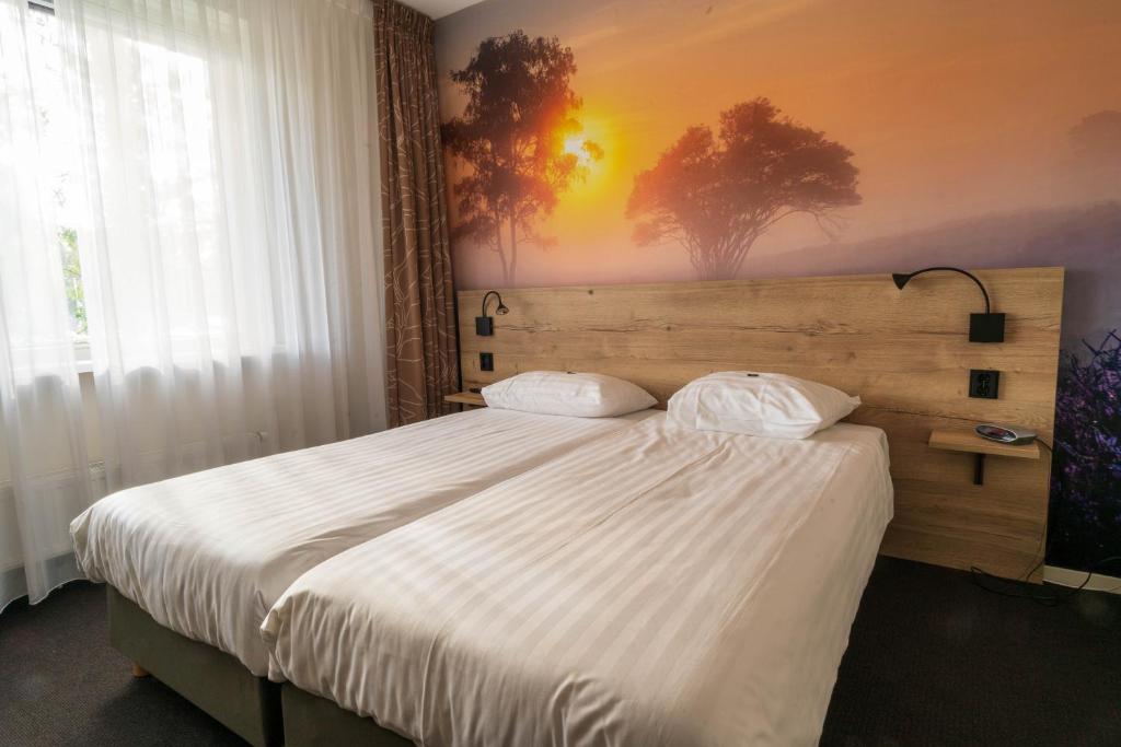 贝克贝亨斯图佩尔堡酒店的一间卧室配有一张带白色床单的大床