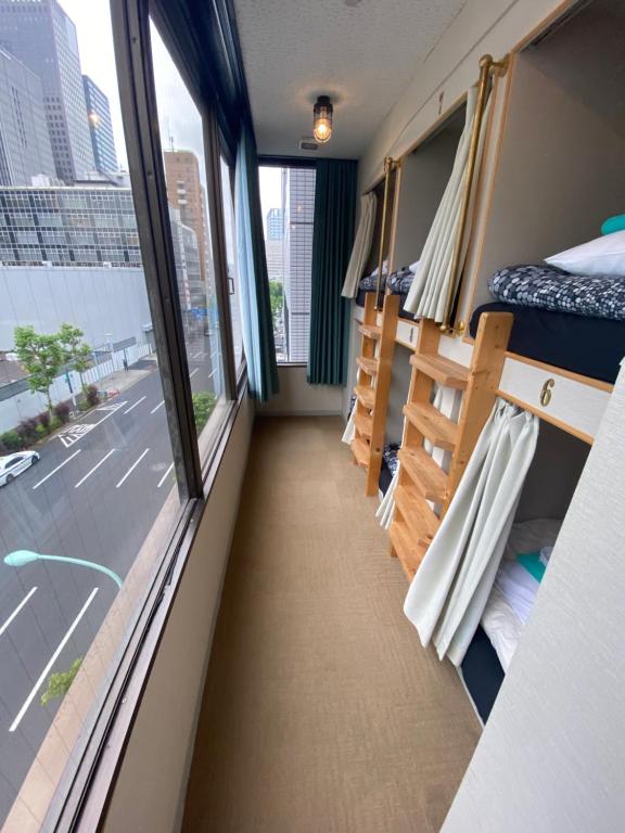 东京54Journey 東京大手町ホステル的公共汽车走廊,带床和窗户