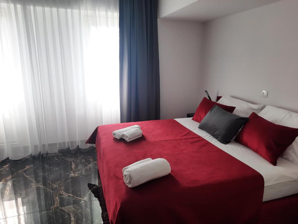 塞扎纳Hotel Prunk的卧室配有红色和白色的床,提供毛巾