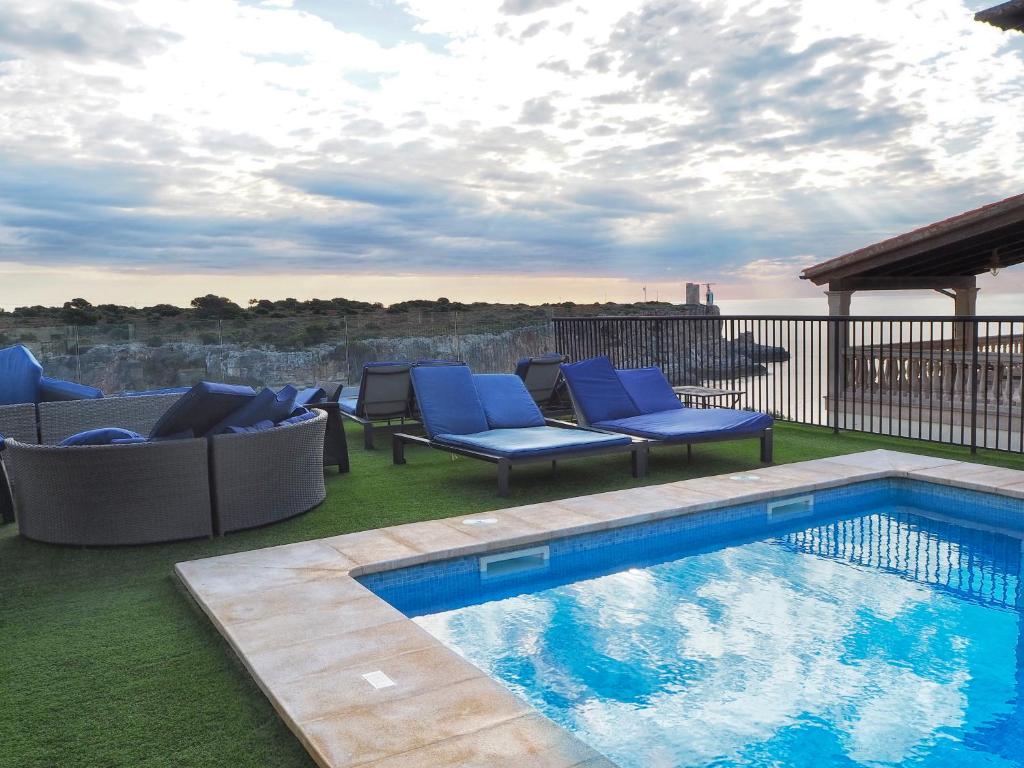 卡拉菲格拉洛卡马尔酒店的一个带蓝色椅子的游泳池