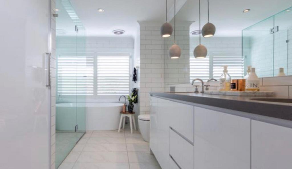 墨尔本The Richmond Cottage的白色的浴室设有浴缸、水槽和卫生间。