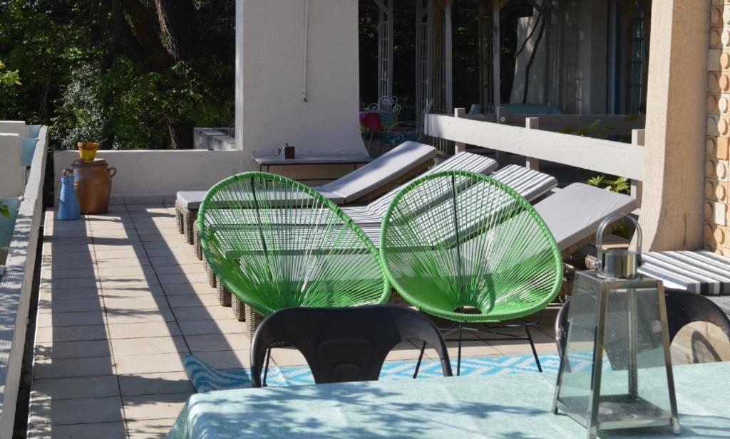 罗纳河畔的图尔农Casa mARTa : Suites, terrasses et vue panoramique的庭院里设有两把绿色椅子和一张桌子