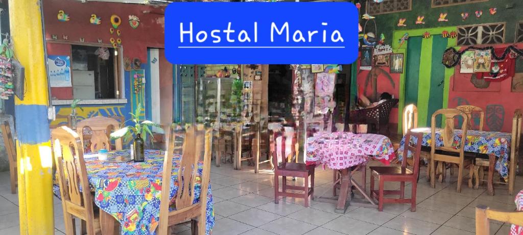 里瓦斯Hostal Maria的一间设有桌椅的餐厅,并标有读医院码头的标志