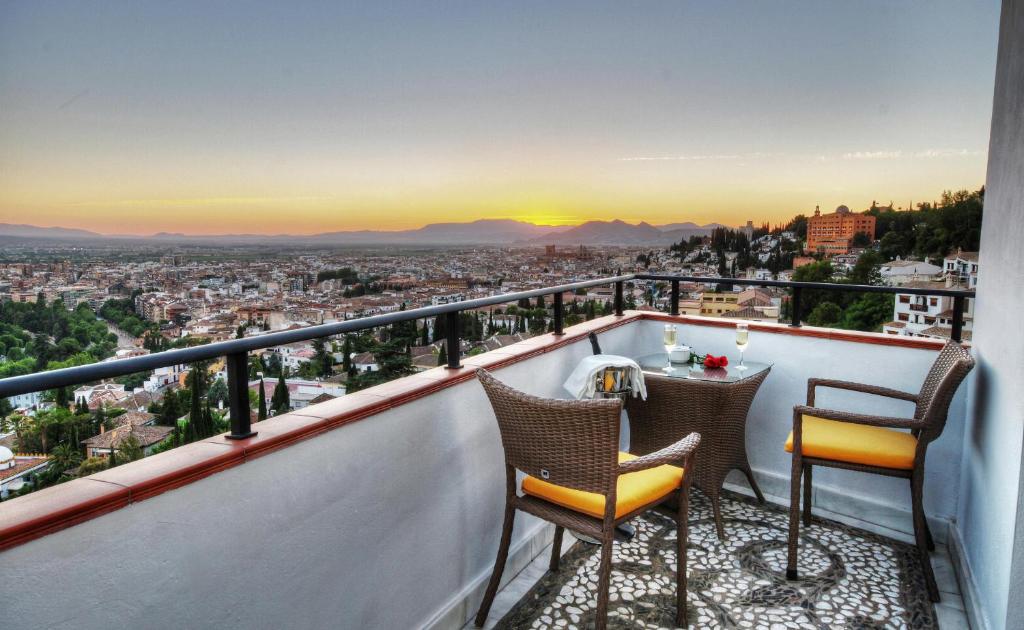格拉纳达米拉多尔阿拉贝鲁赫酒店的阳台配有2把椅子和1张桌子,享有风景。
