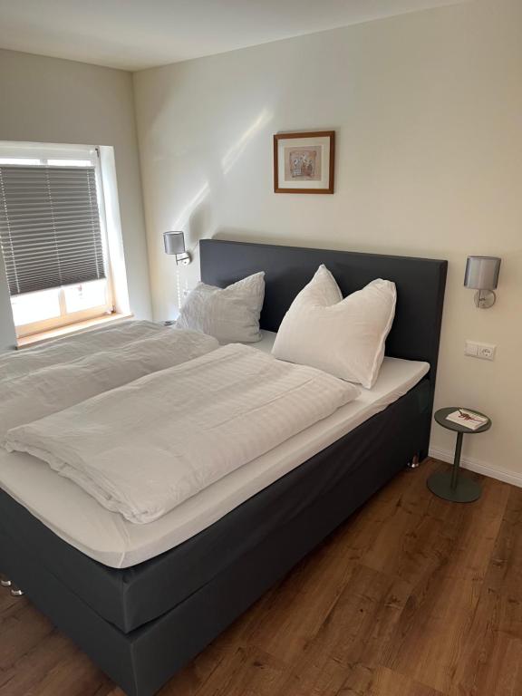 格赖夫斯瓦尔德Im Zentrum, praktisch und ruhig的卧室内的一张带白色床单和枕头的床
