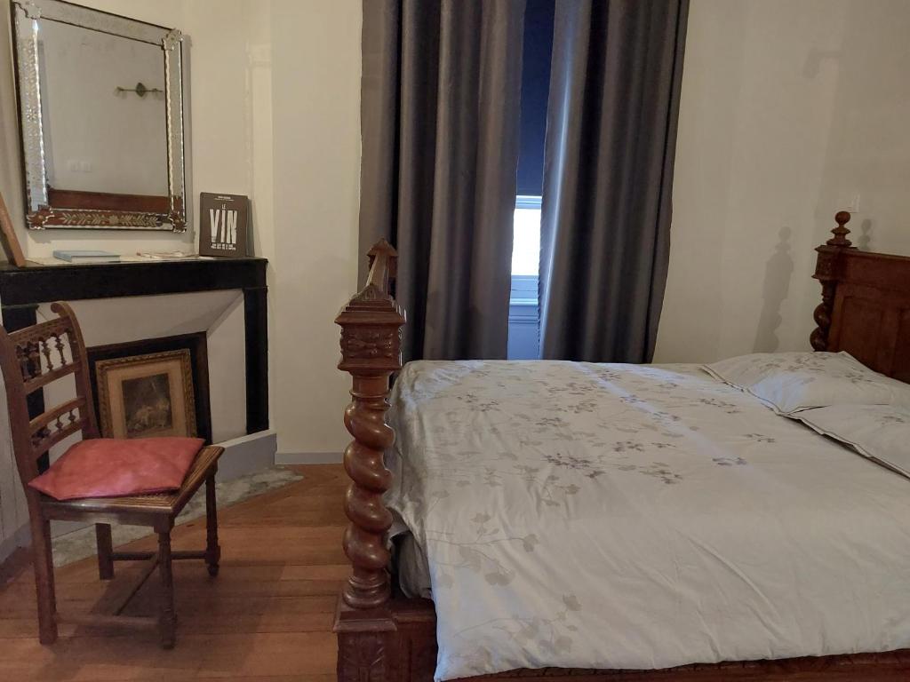 维列莫尔贡Domaine de Fond Chatonne的一间卧室配有一张床、镜子和椅子