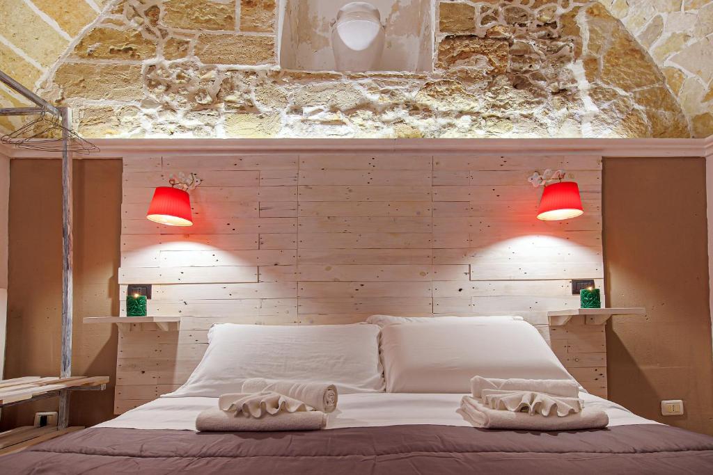 莱韦拉诺艾克德拉度假小屋的一间卧室配有红色灯的白色床