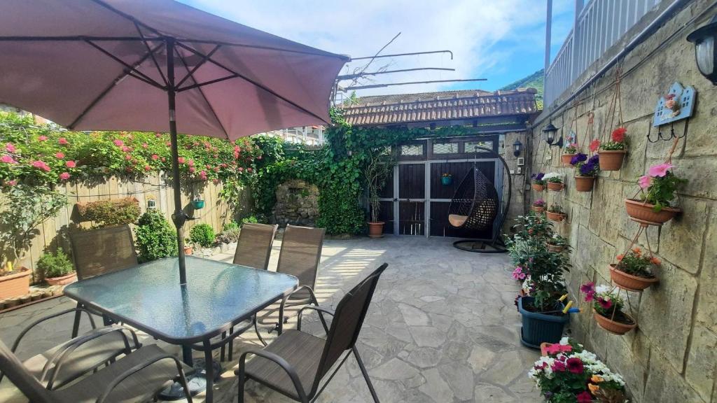 姆茨赫塔villa saba with two bedrooms - სასტუმრო საბა的庭院配有桌椅和遮阳伞。