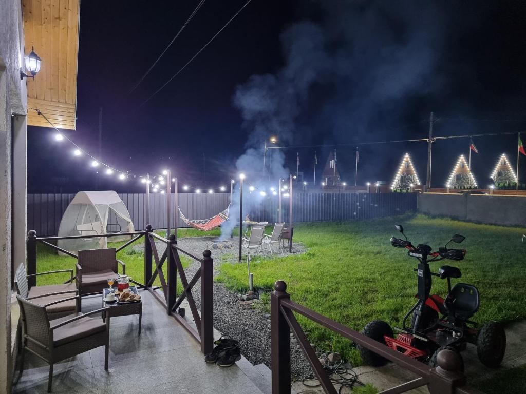 博尔若米Borjomi Plato house的夜晚在院子里有帐篷和摩托车的房子