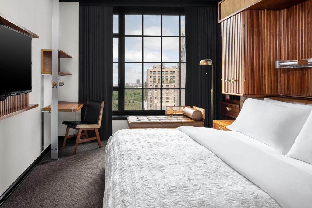 纽约Le Meridien New York, Central Park by Marriott的酒店客房设有一张大床和一张书桌。