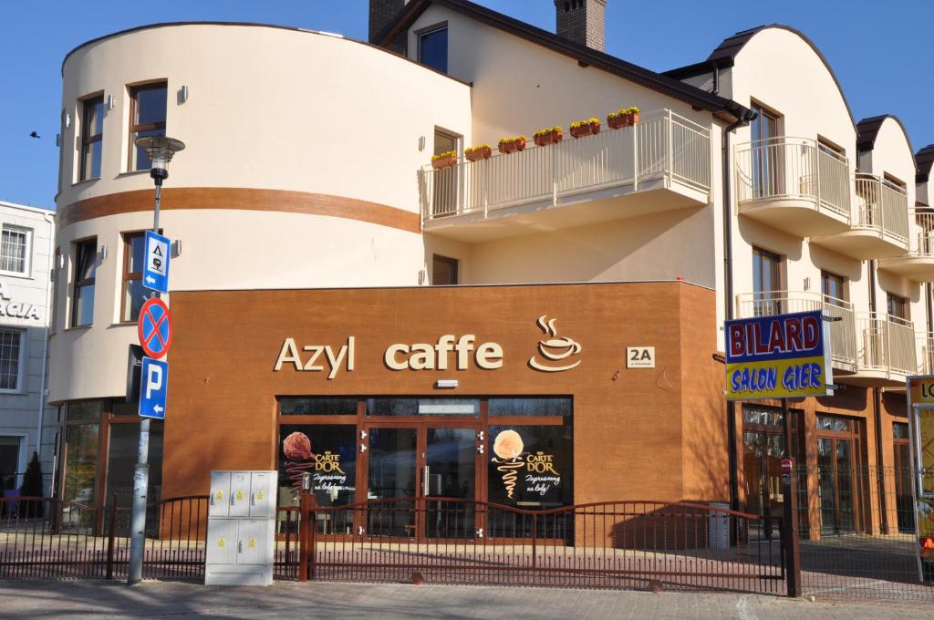 尤斯托尼莫斯基阿滋依旅馆的城市街道上一座有aaza咖啡馆的建筑