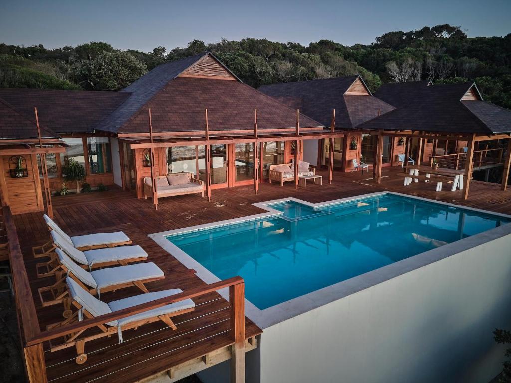 Ponta MamoliAloha 10 I 4Bed Villa with Stunning Sea View Pool的一个带椅子的游泳池以及一座房子