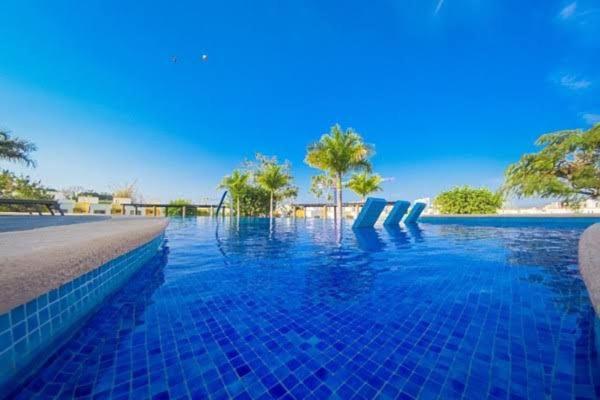 布塞里亚斯Casa Los Amores的一座拥有蓝色海水和棕榈树的游泳池