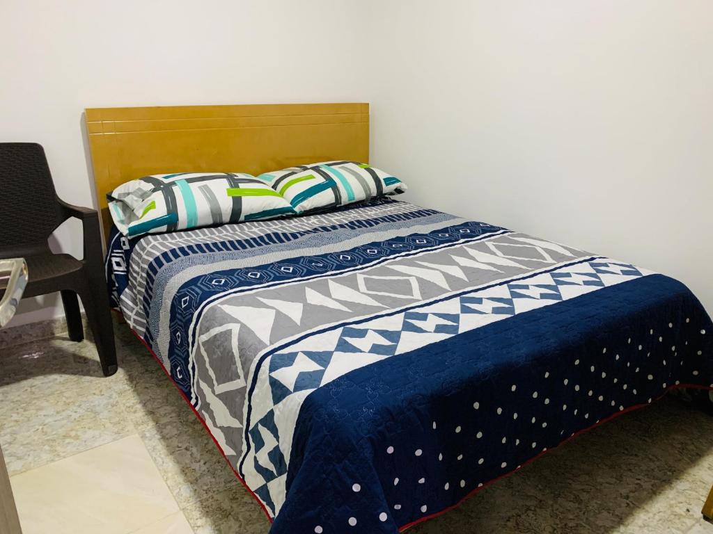 波哥大Bogotá Kings 302的一张带蓝色和白色棉被和枕头的床