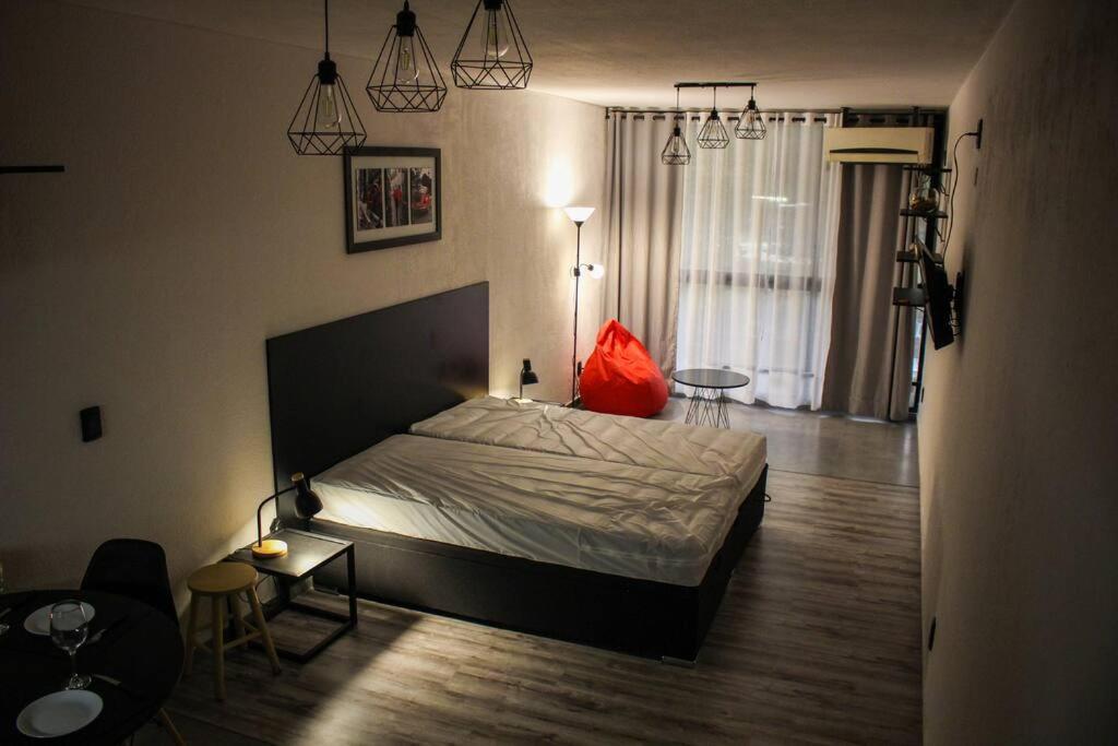 蒙得维的亚Apart Hotel Montevideo的一间卧室配有一张红色枕头的床