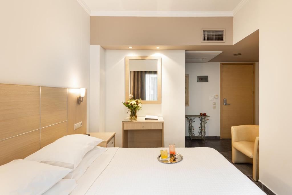 塞萨洛尼基埃尔格雷柯酒店的酒店客房配有一张床铺和一张桌子。