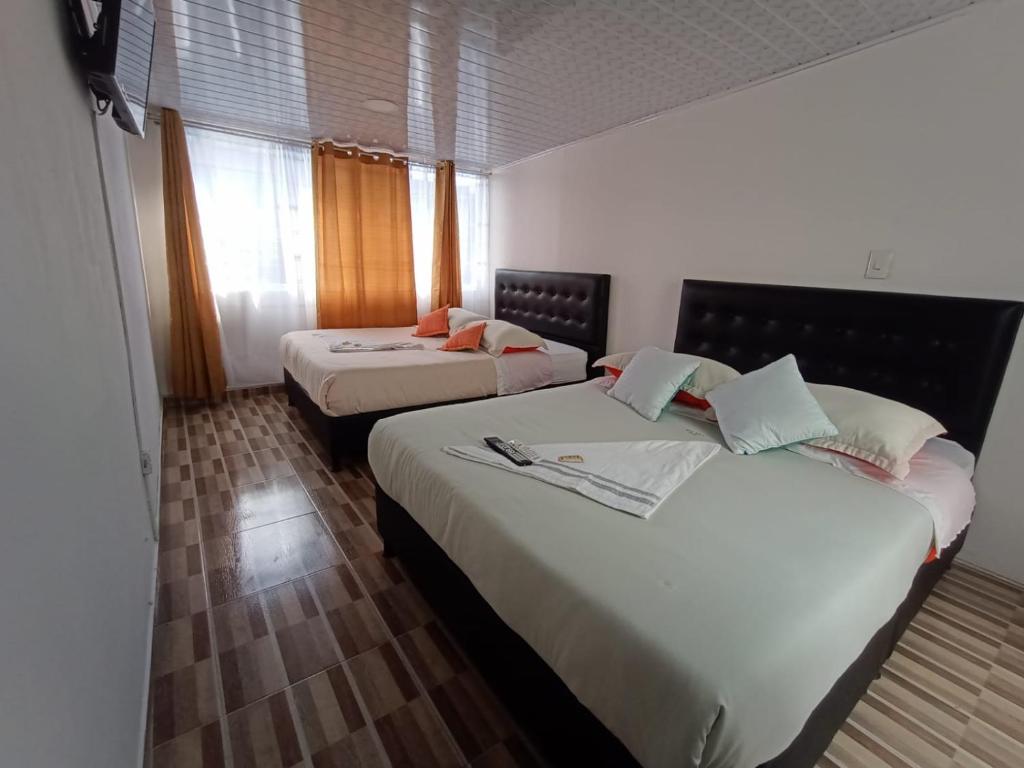 波哥大HOTEL BOGOTA AIRPORT DORADO的酒店客房设有两张床和窗户。