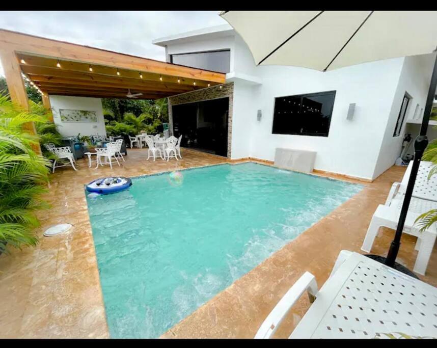 璜多里奥Beautiful Home and Pool near beach , BBQ Juan Dolio metro country Club的一座房子后院的游泳池