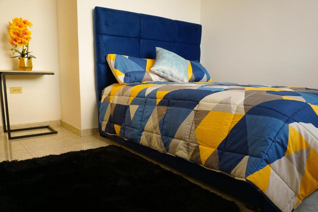 曼塔Casa Familiar con Piscina en Urbanización privada的客房内的蓝色和黄色的床