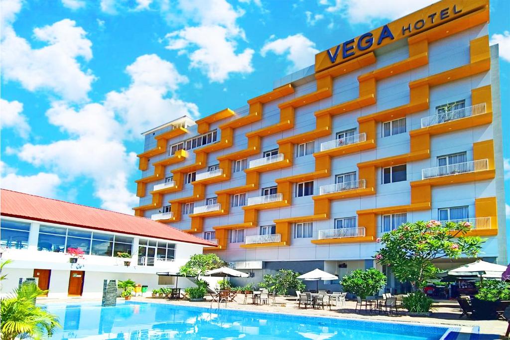 索龙Vega Prime Hotel & Convention的大楼前设有游泳池的酒店