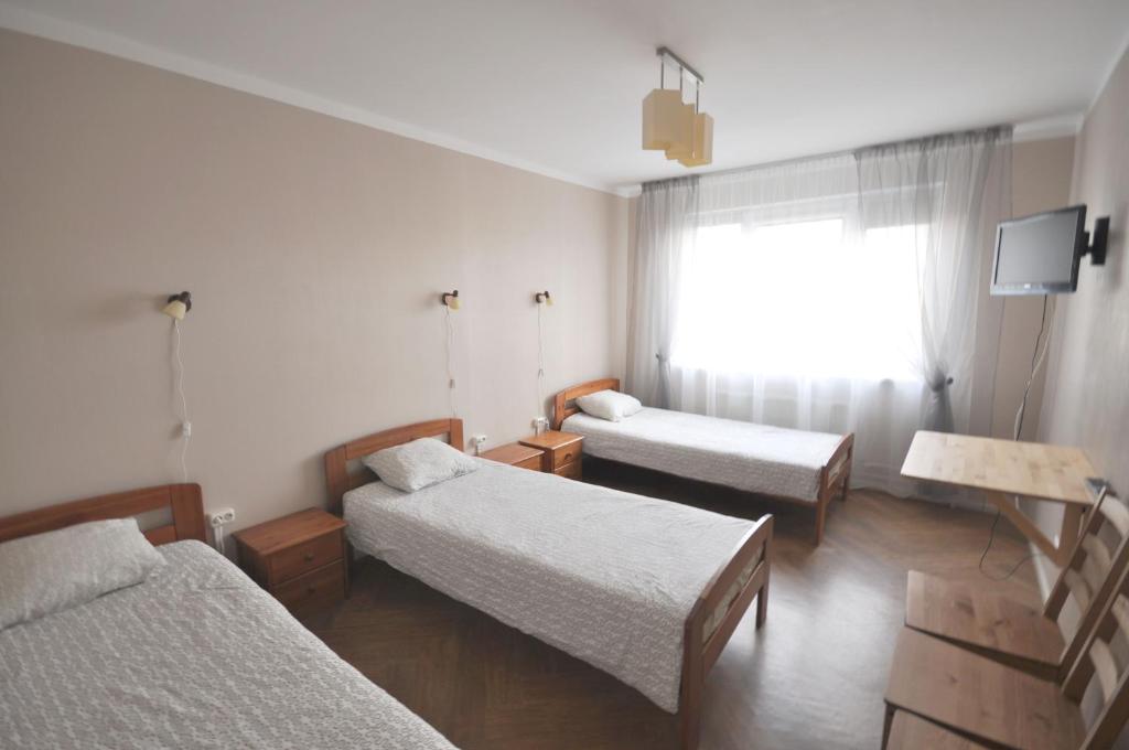 叶卡布皮尔斯Apartamenti Jēkabpilī的带三张床和窗户的客房
