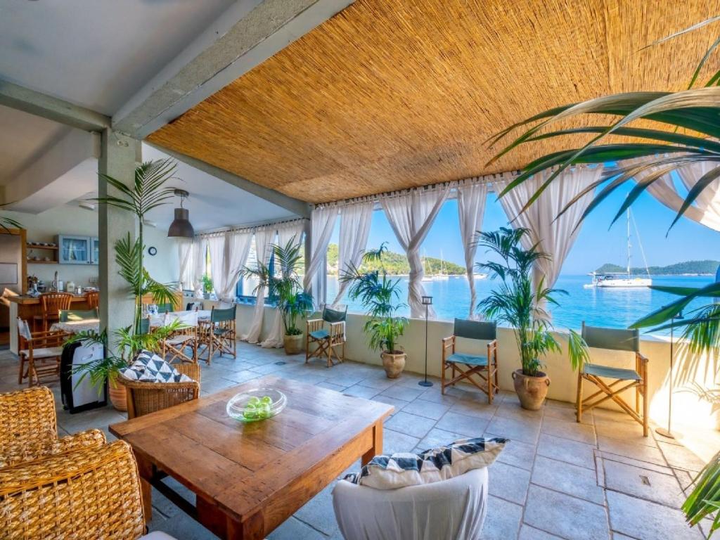洛帕德Villa Lola的一间带桌椅和海洋的客厅