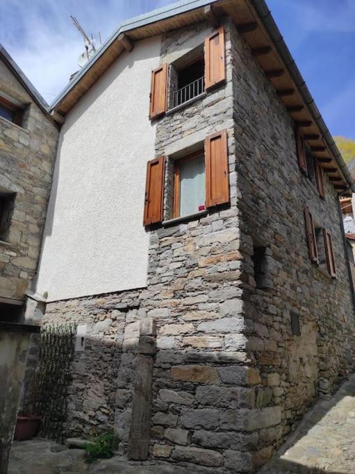 MusignanoResidenza Campagnano的一座古老的石头建筑,设有窗户和阳台