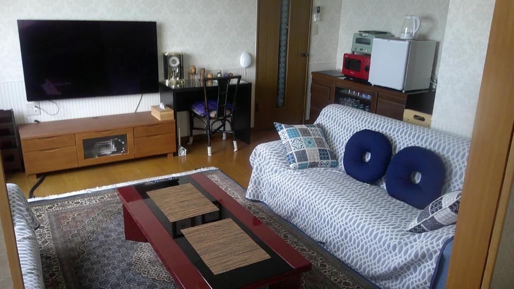 札幌旅の宿ていね的带沙发和电视的客厅
