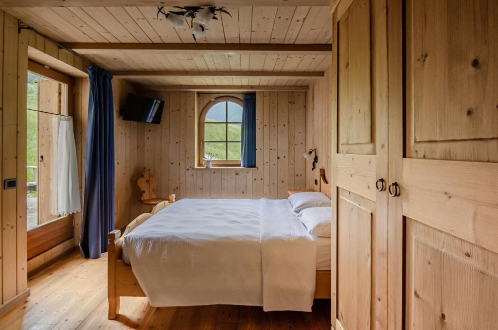 拉比Hotel Chalet val di Rabbi的木制客房内的一间卧室,配有一张床