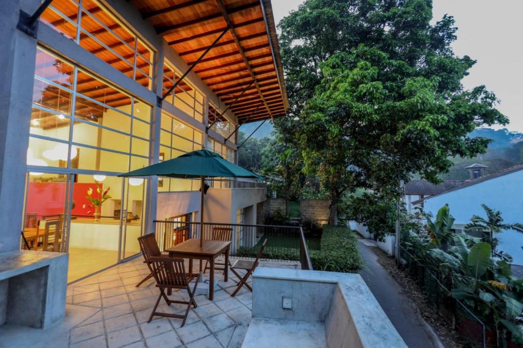 康提Margossa Residence by 55TG的庭院配有椅子和桌子及遮阳伞