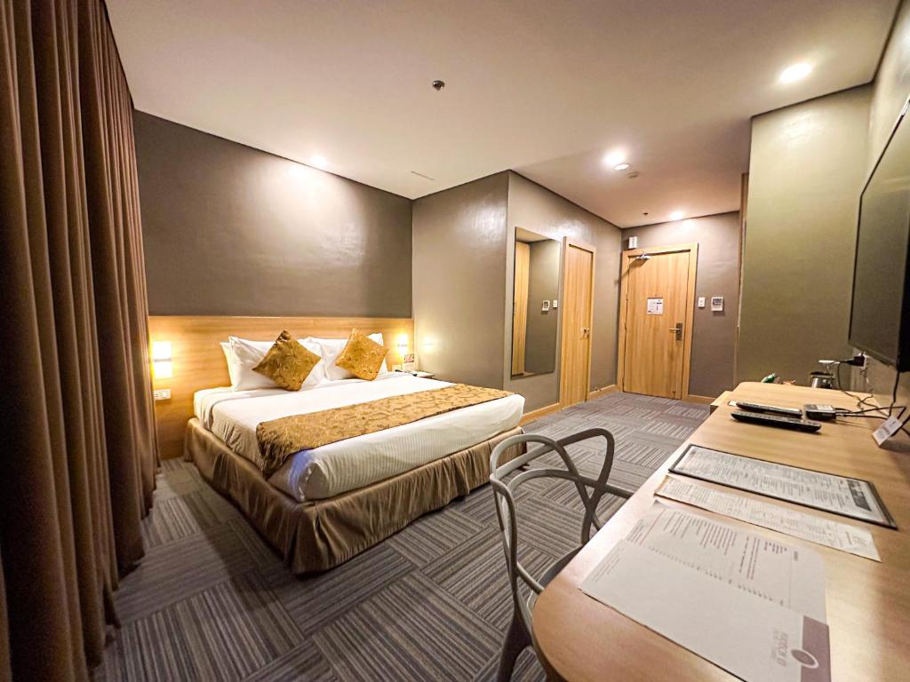 马尼拉麦迪逊塔楼101酒店的配有一张床和一张书桌的酒店客房