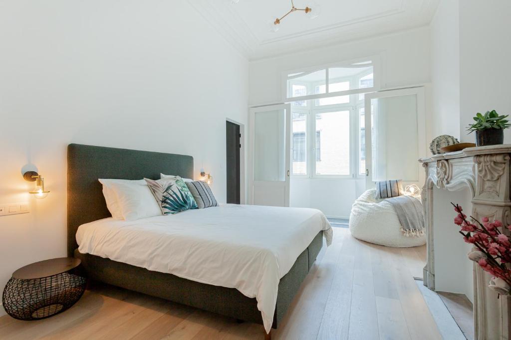 根特RODELIJV的白色的卧室设有一张大床和一个窗户