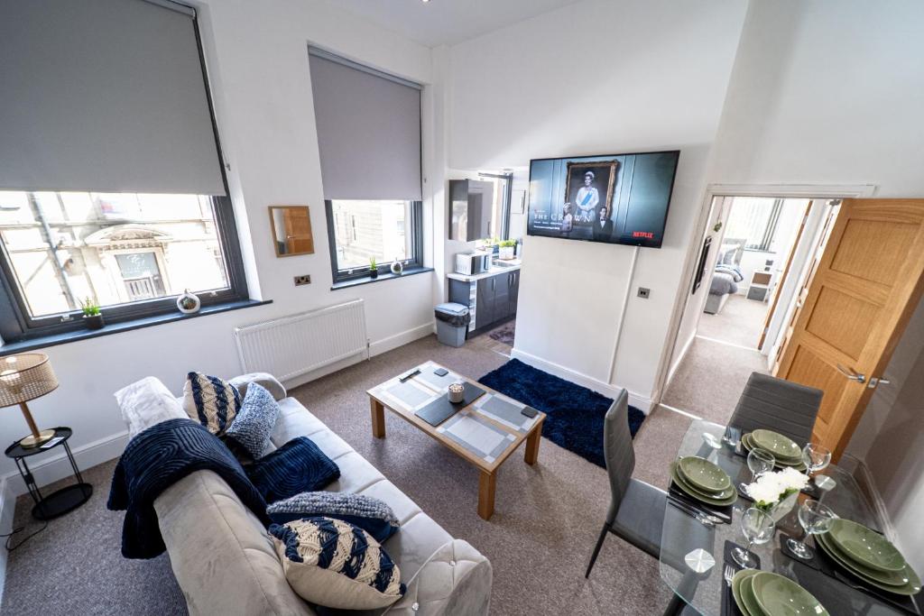 巴恩斯利Cozy 1-Bedroom Apartment in the Heart of Barnsley Town Centre的客厅配有沙发和桌子