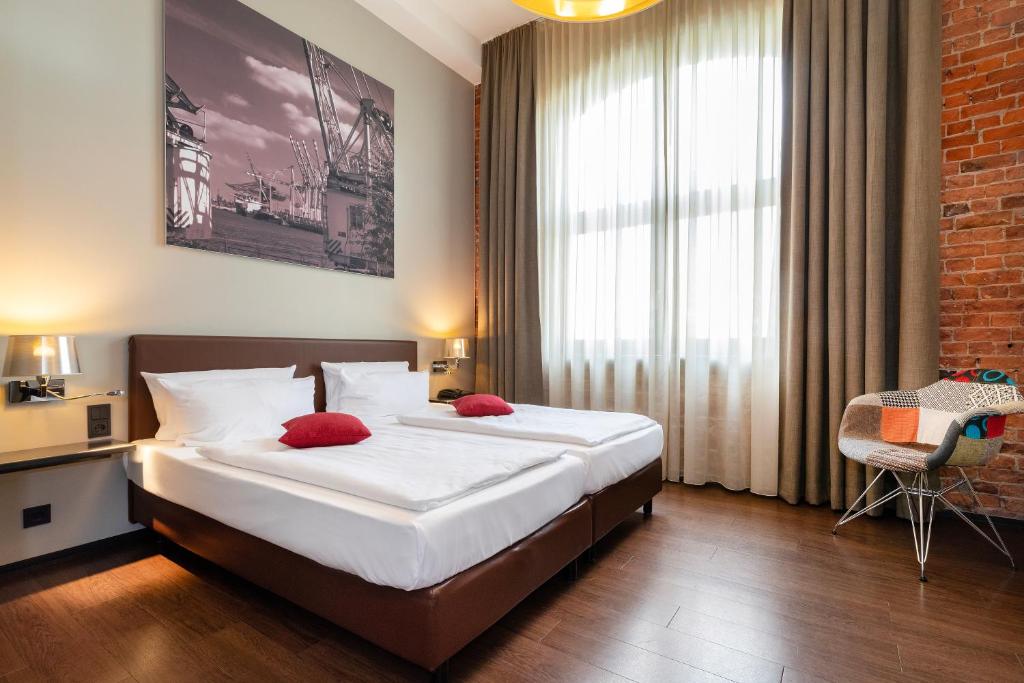 汉堡Hotel Volksschule的一间卧室配有一张带红色枕头的大床