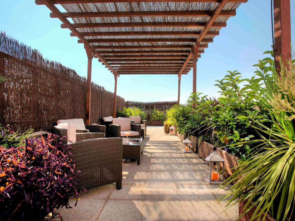 格拉纳达宜必思格拉纳达酒店的一个带椅子和植物的庭院和一个木制凉亭