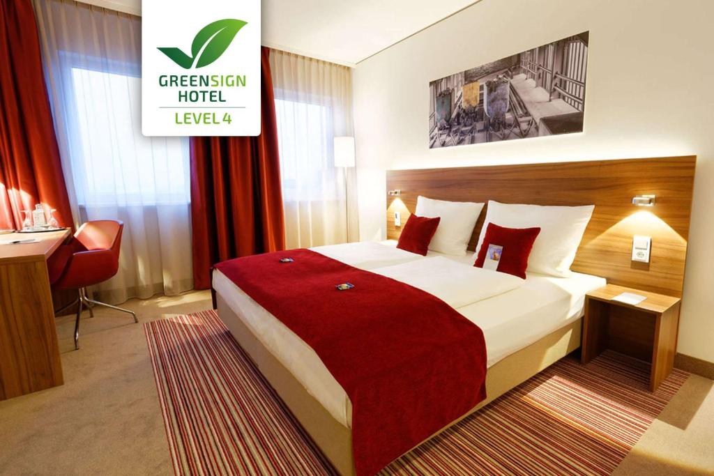 埃森埃森住宿酒店的酒店客房设有一张带红色毯子的大床