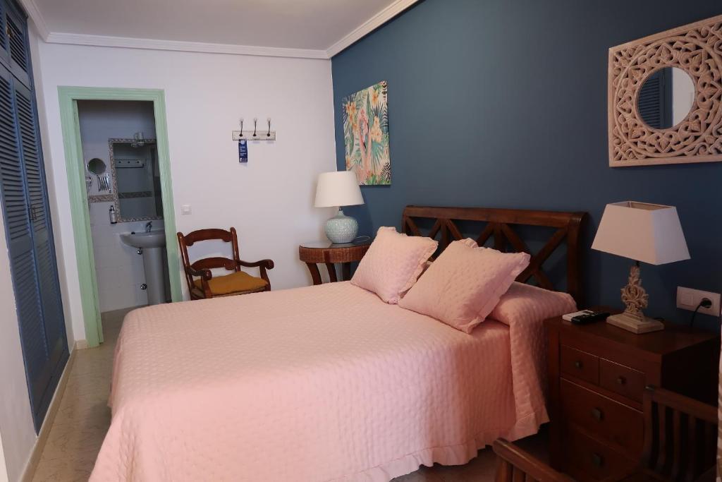 奇皮奥纳罗普里塞普拉亚酒店的一间卧室配有一张带粉红色床单和蓝色墙壁的床。