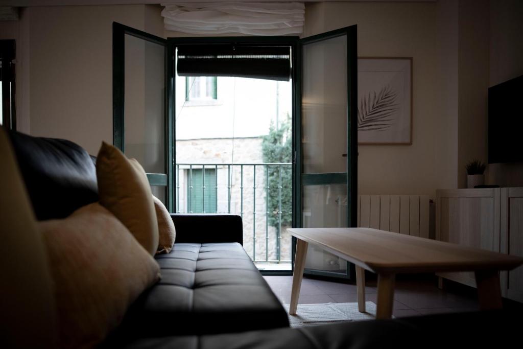圣洛伦索-德埃斯科里亚尔Apartamento Exterior 2 dormitorios en CENTRO HISTÓRICO的带沙发、桌子和窗户的客厅