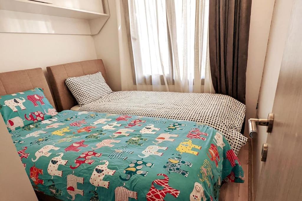 米拉斯Sea Breeze Apartment的一间小卧室,配有一张带绿色棉被的床