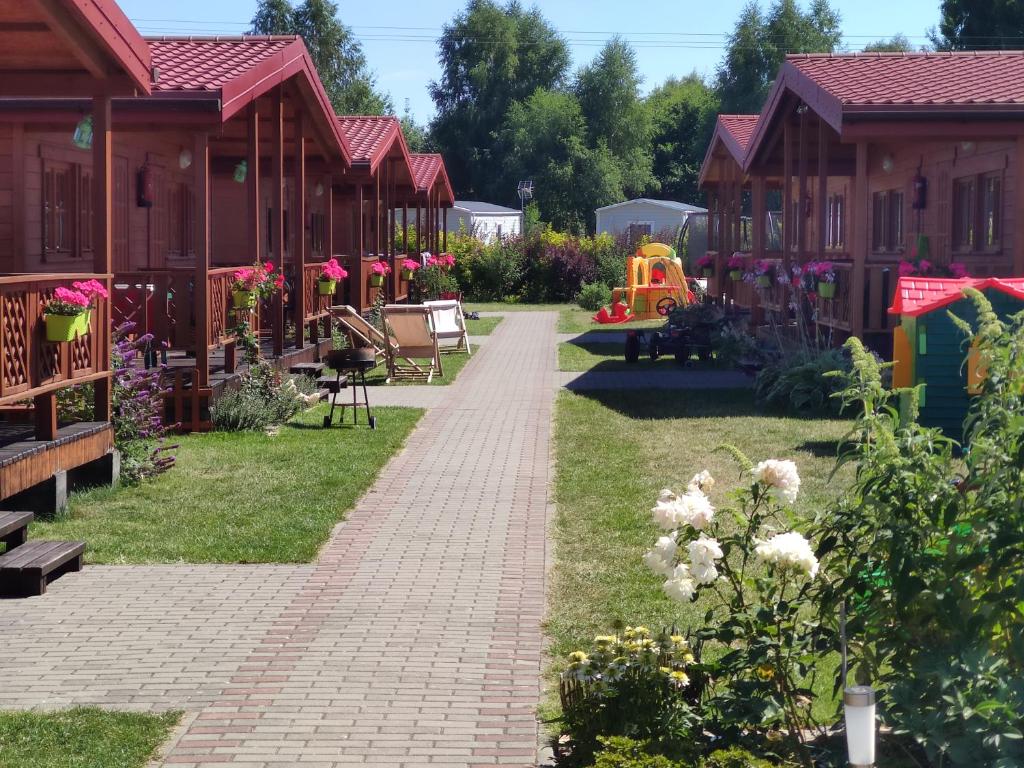 达布基Oaza Dąbek的穿过鲜花盛开的房屋花园的步道