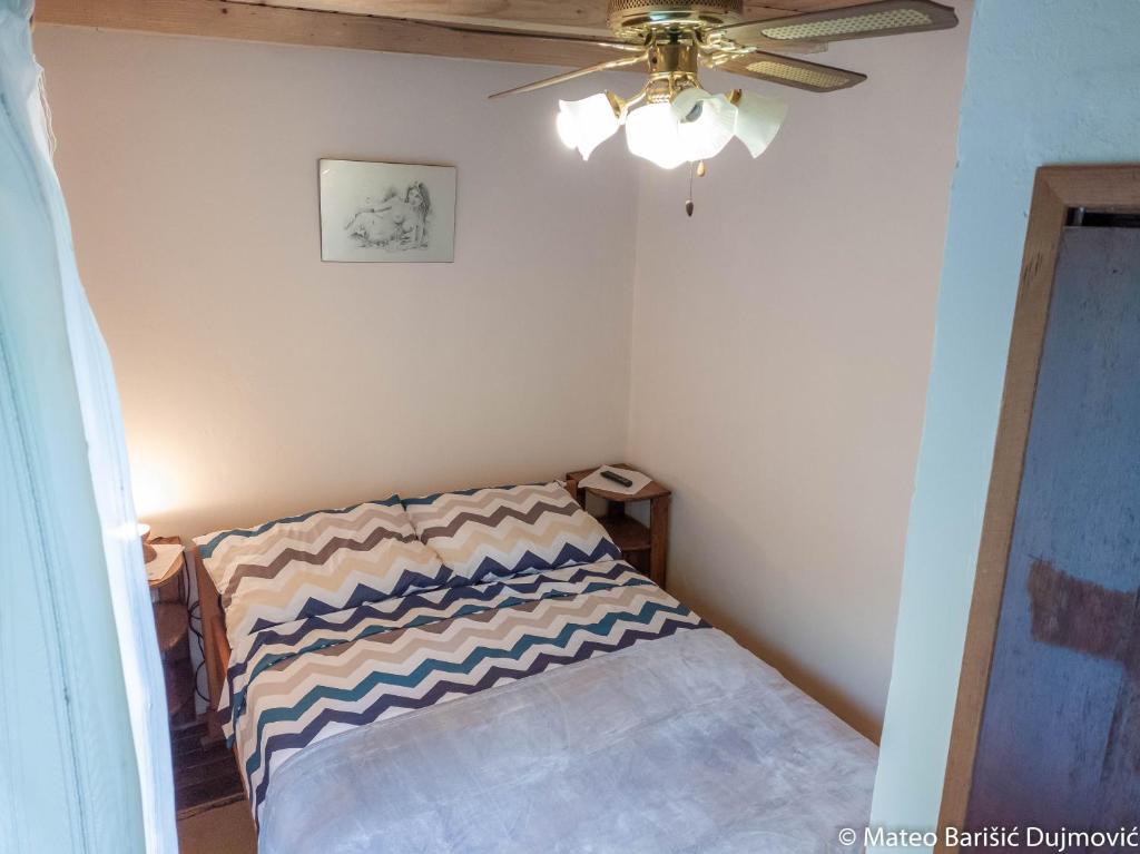 里斯卡Apartman Kos的一间小卧室,配有一张带吊扇的床