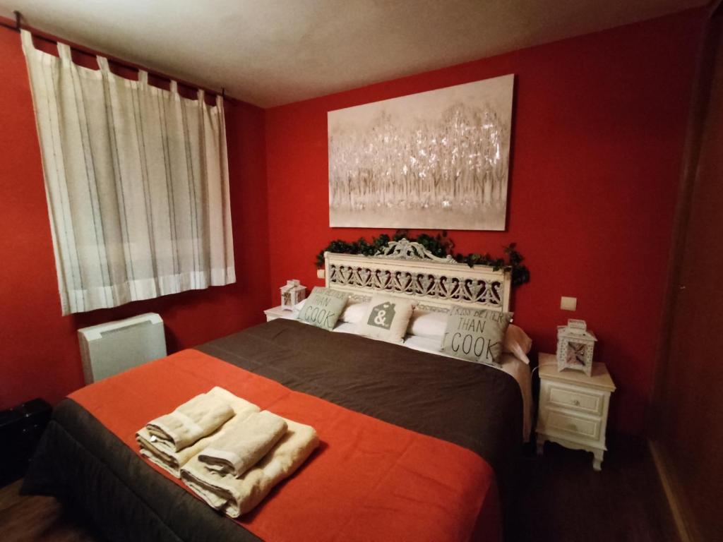 Collado MedianoApartahotel Rural CollaRubio Luxury的一间红色卧室,房间内设有一张大床