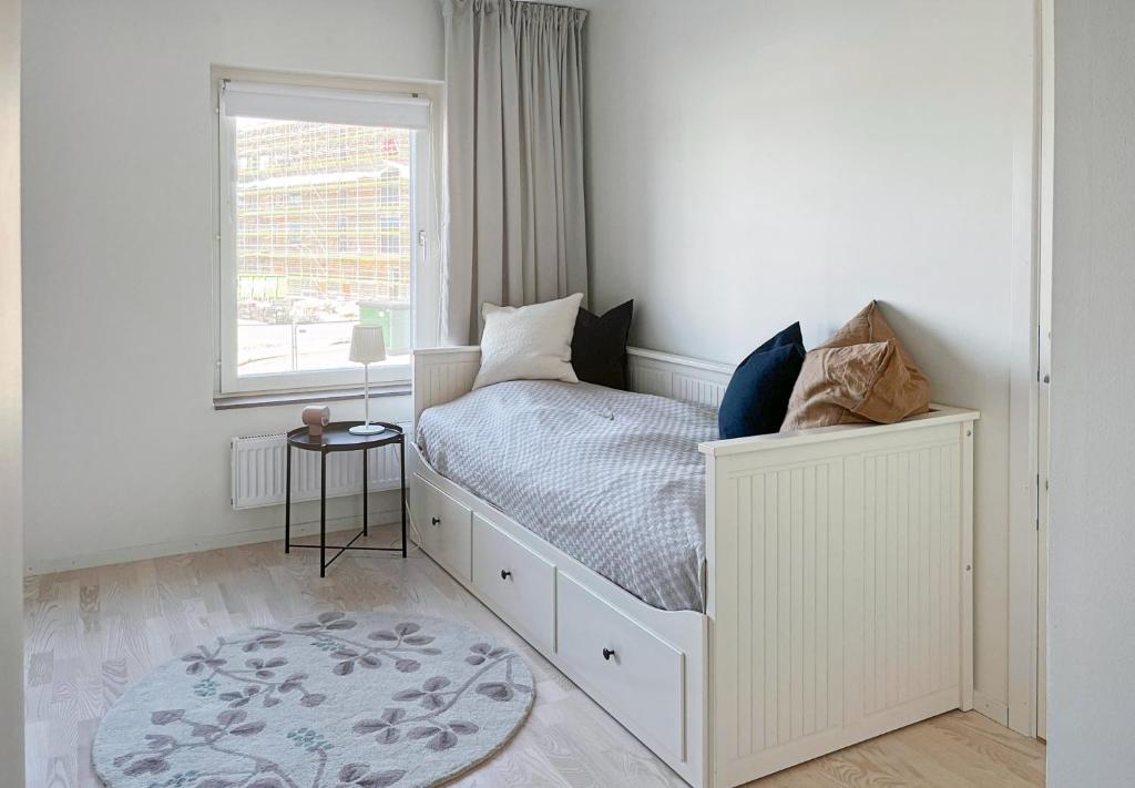 马尔默Hyllie Appartement - New Construction的白色的卧室设有床和窗户