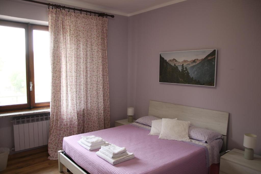 阿维利亚纳Bed And Breakfast Del Lago的卧室配有粉红色的床和窗户。