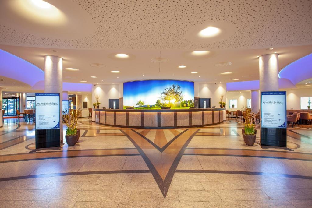 维林根赛尔兰德斯特恩酒店 的大楼内带大屏幕的大堂