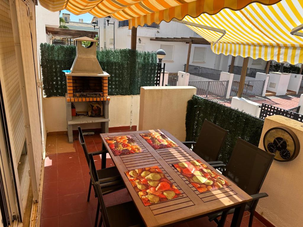 阿尔考斯布里Casa adosada con piscina y dos terrazas的庭院里配有桌椅和食物