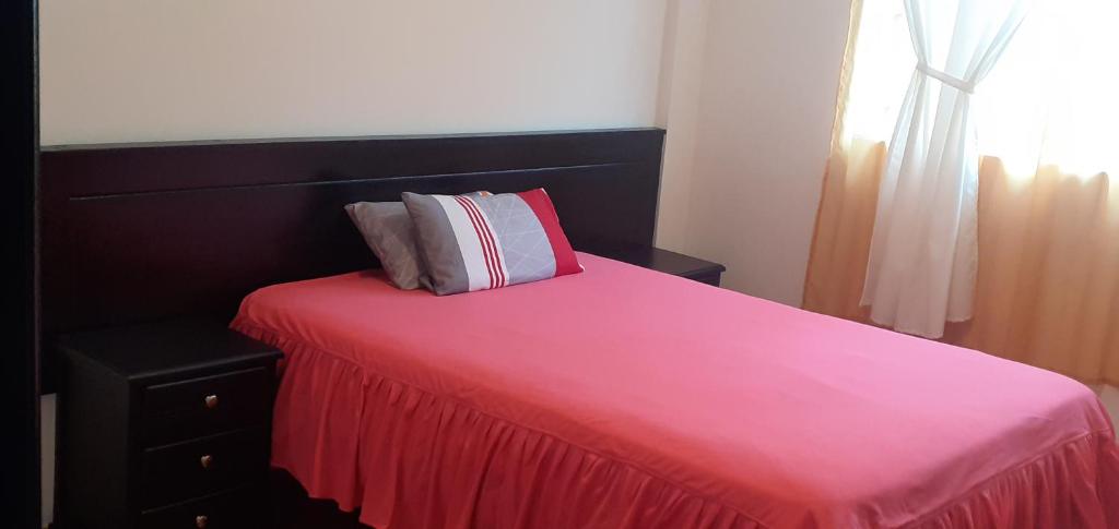 San Juan de IlumánCasa campestre en las faldas del Taita Imbabura的一间卧室配有一张粉红色的床和红色毯子