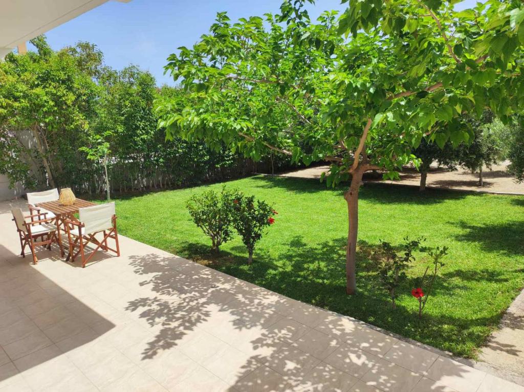 阿斯格罗Rhodes Soul Iuxury home的庭院里种着桌子和树